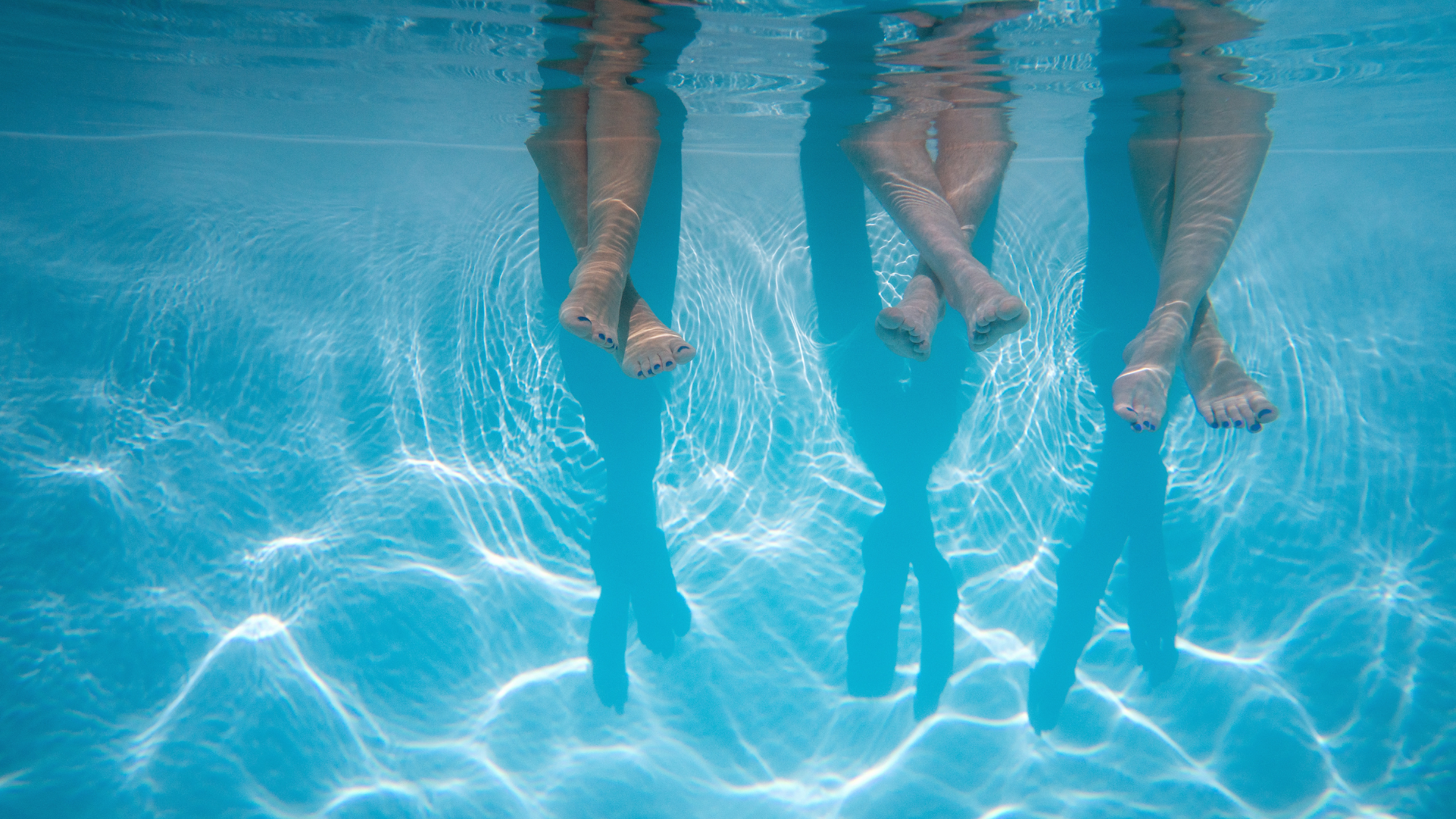 Women with legs in pool underwater